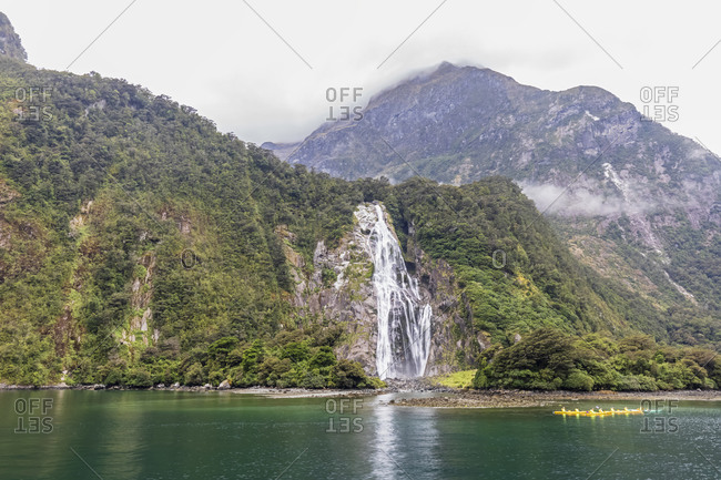 New Zealand- Oceania- South Island- Southland- Fiordland National Park- Port of Milford Sound with Bowen Falls and Barren Peak- Canoeists on water