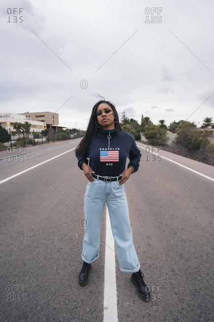 Portrait of cool young woman standing on a road