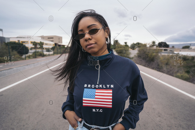 Portrait of cool young woman standing on a road