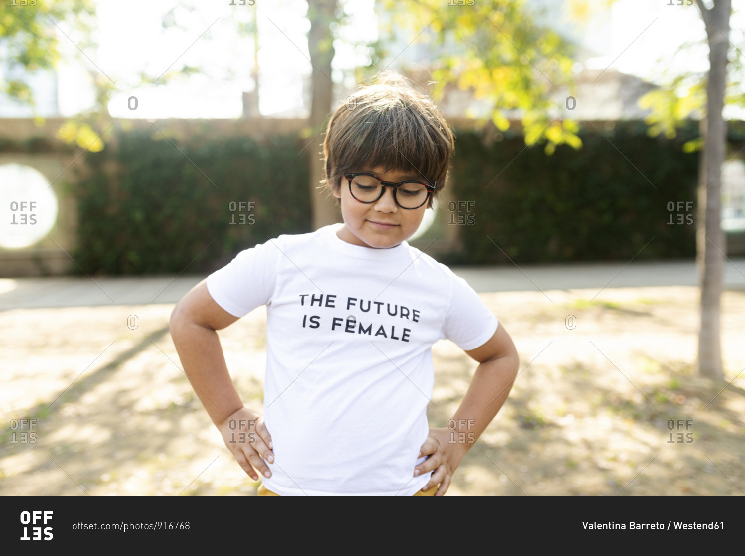 Proud little boy standing in the street with print on t-shirt- saying the future is female