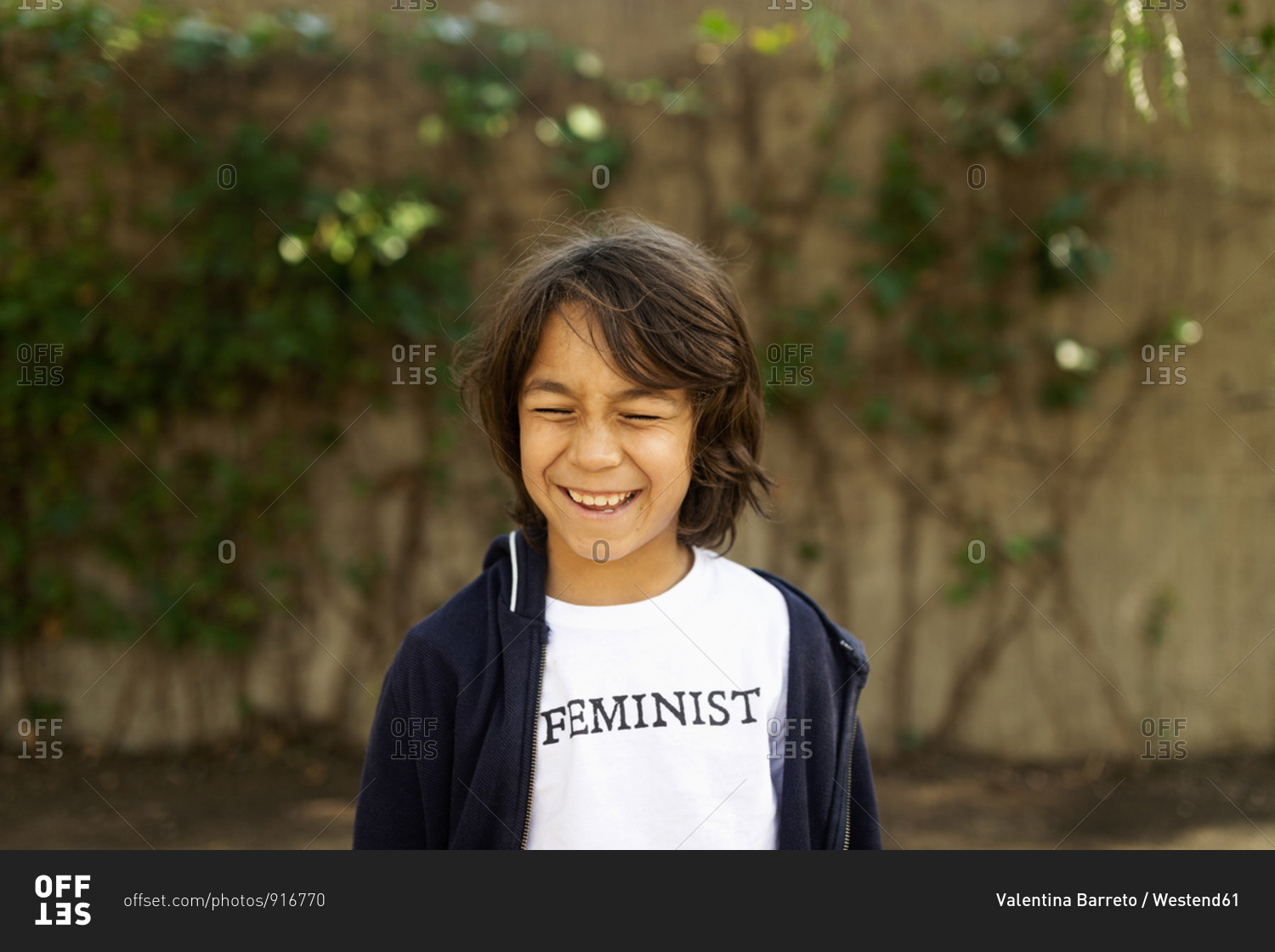 Laughing boy standing in the street with print on t-shirt- saying Feminist