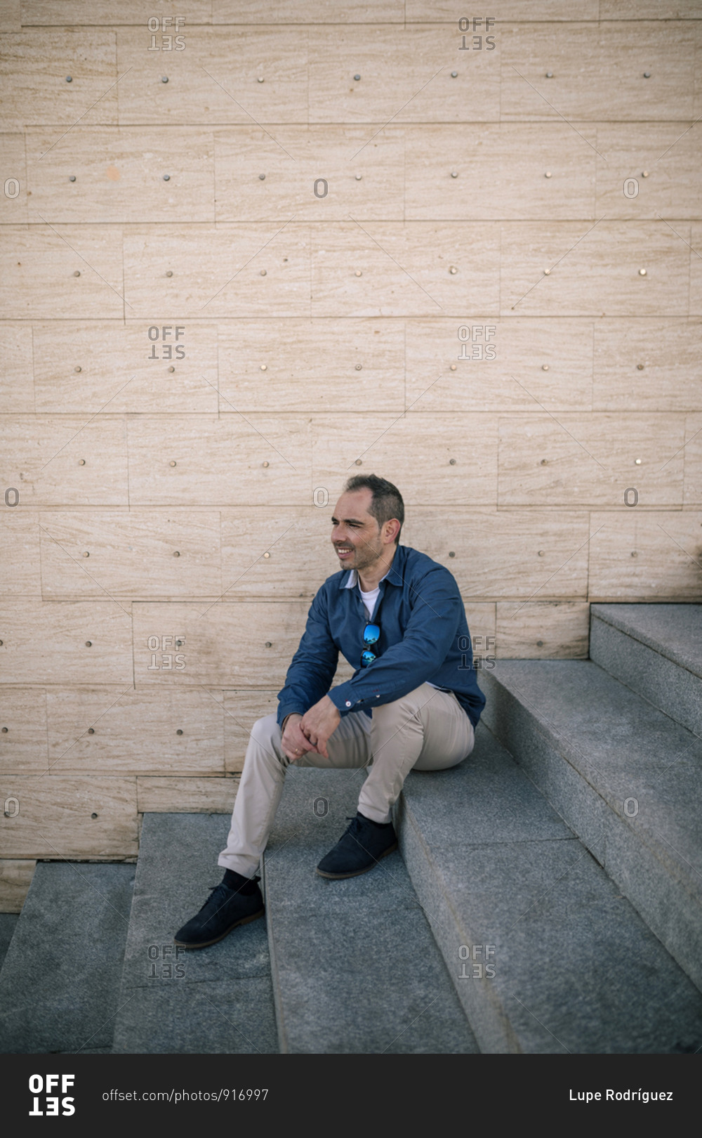 Portrait of 40-year-old man sitting on stairs outdoors