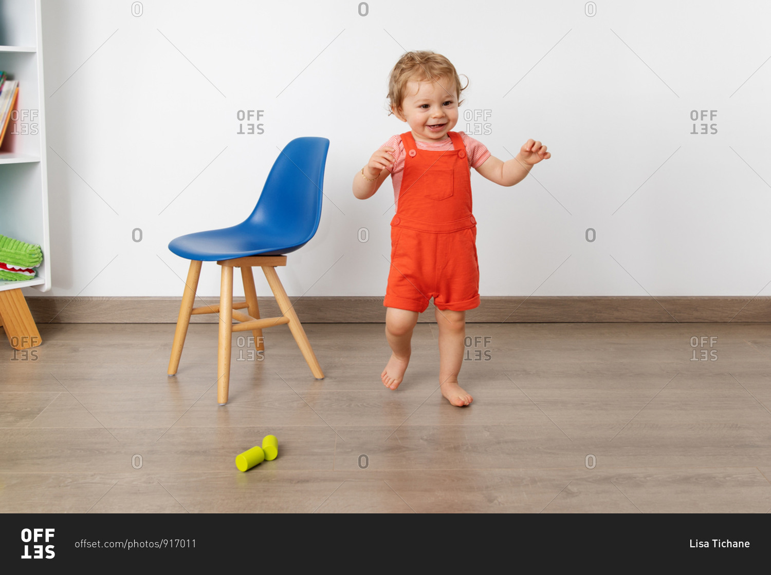 Smiling baby making first steps in playroom