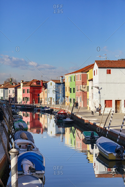 Venice, Italy - January 2, 2019: Colorful houses in Burano with canal and moored boats