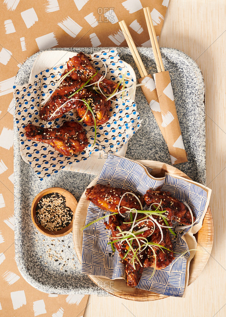 Korean BBQ chicken wings with spring onions with chopsticks and graphic patterned napkins