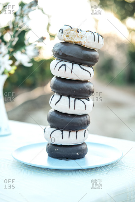 Yummy donuts with icing and chocolate ganache stacked on plate