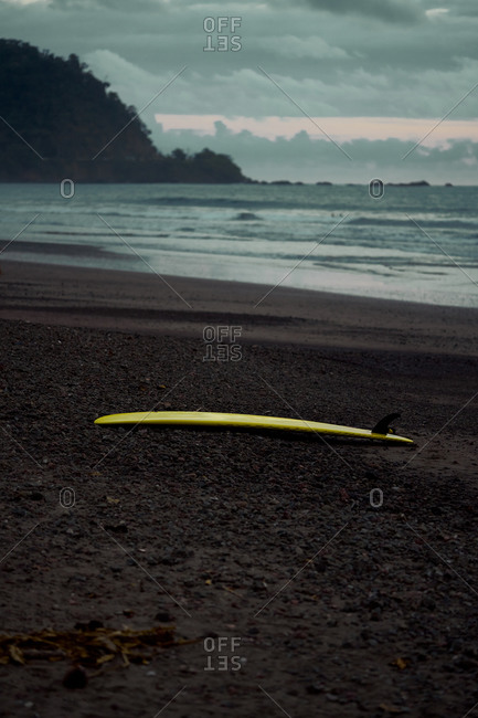 Picturesque scenery of surfboard on sandy beach in twilight in Costa Rica