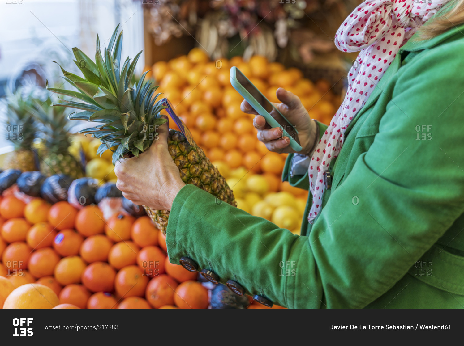 Woman using smartphone app to check a pineapple