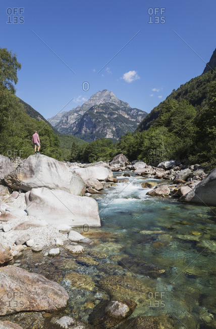 Man standing on rock at Verzasca river- Verzasca Valley- Ticino- Switzerland