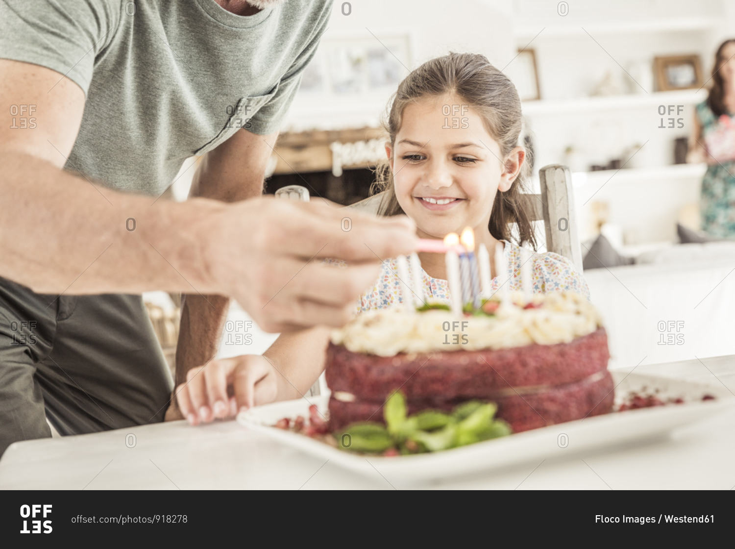 Crop view of father lighting candles on birthday cake