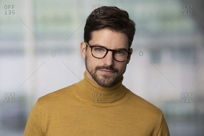 Portrait of confident man wearing glasses and yellow sweater