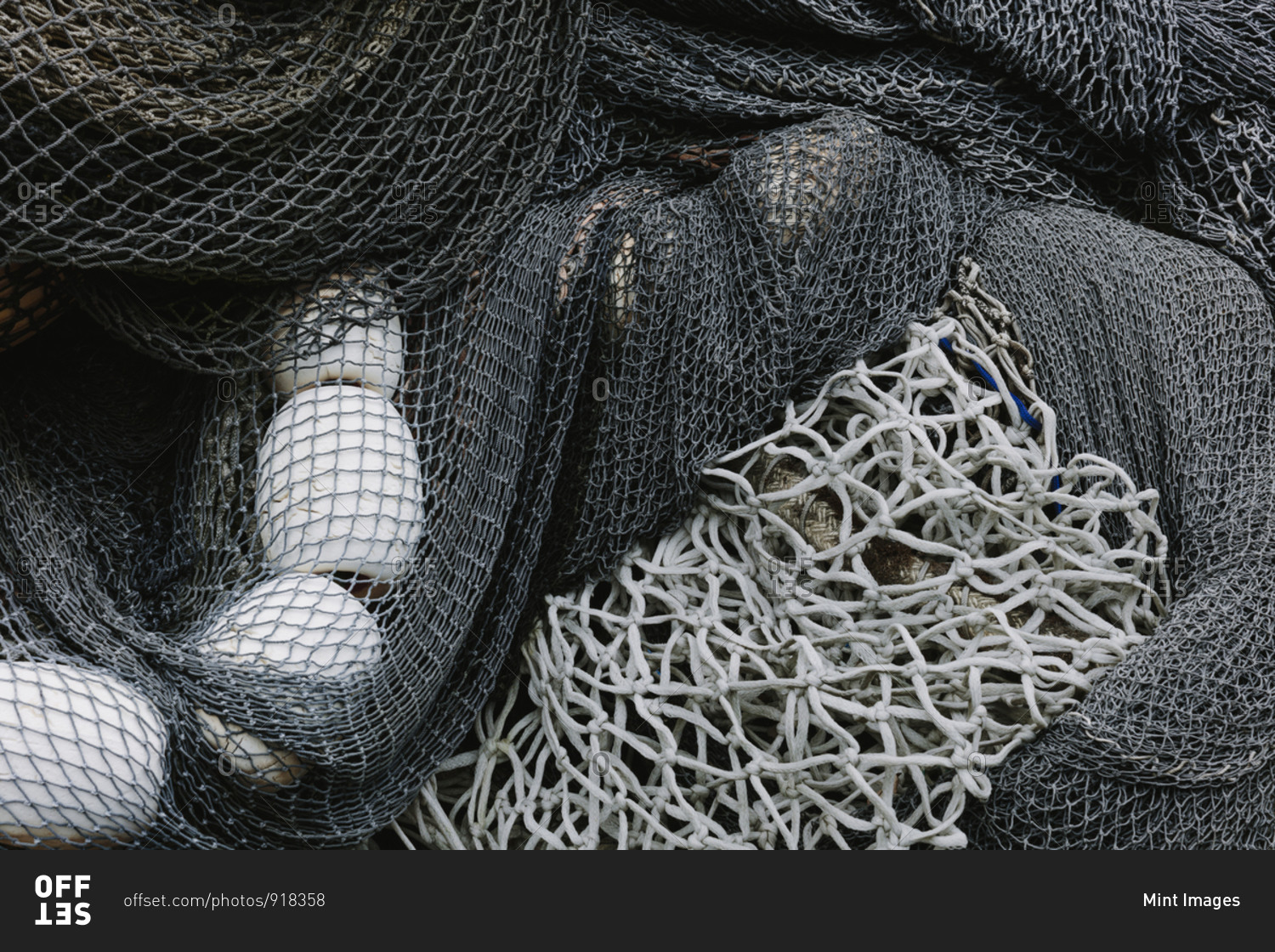 Pile of commercial fishing nets and gill nets on a fishing quay.