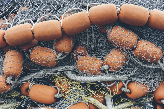 Pile of commercial fishing nets and gill nets on a fishing quay.