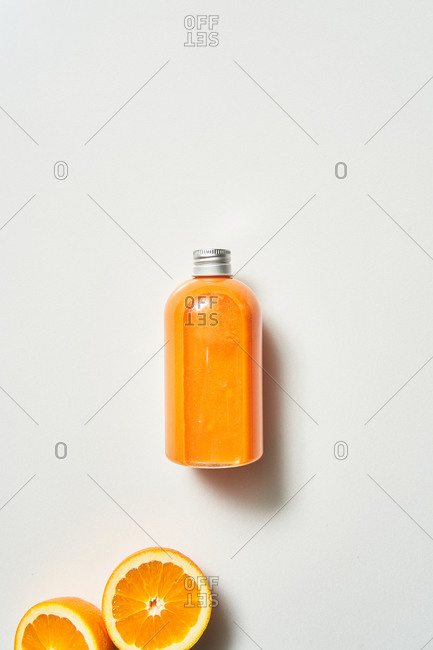 Fresh squeezed orange juice and oranges on white background