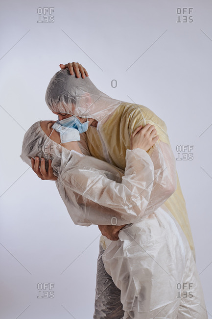 Couple embracing in full coverage protective coveralls