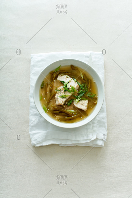 Miso soup with green beans and chicken on textile background