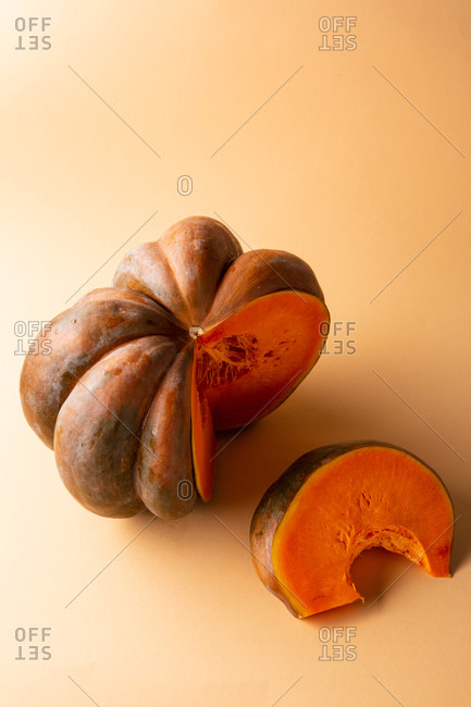 Orange pumpkin sliced on orange background