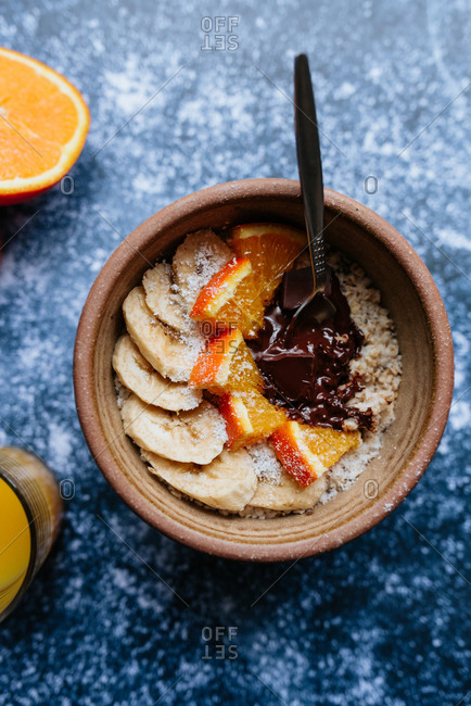 Close up of a bowl of oatmeal with chia seed, bananas and oranges