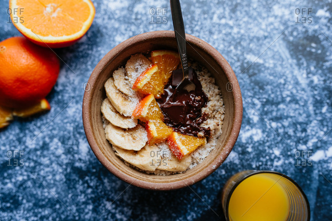 Top view of oatmeal with chia seed, bananas and oranges