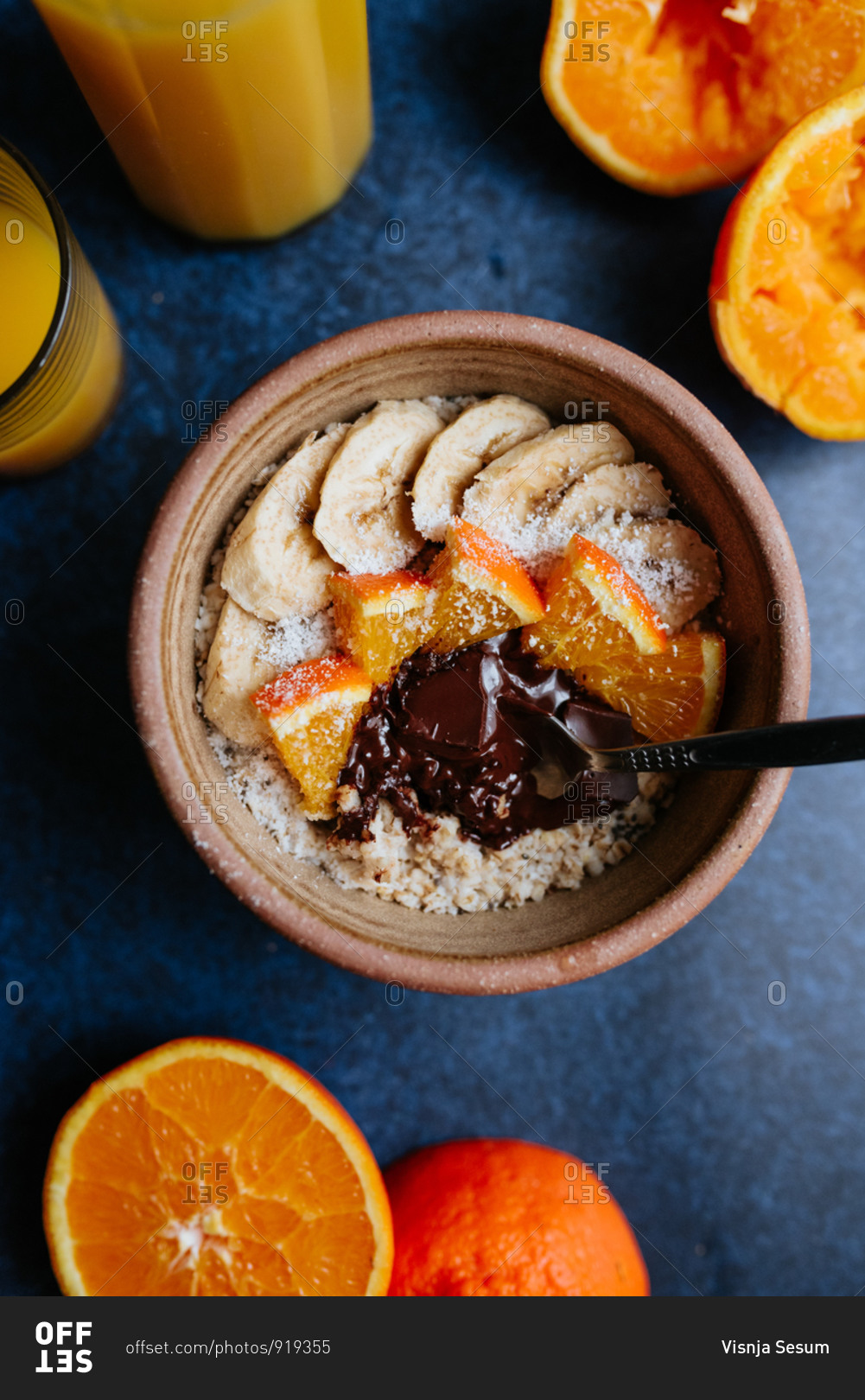 Oatmeal with chia seed, bananas and oranges on blue background from above