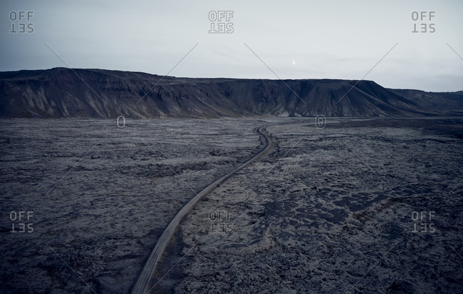 Road winding through dry dark valley in mountain