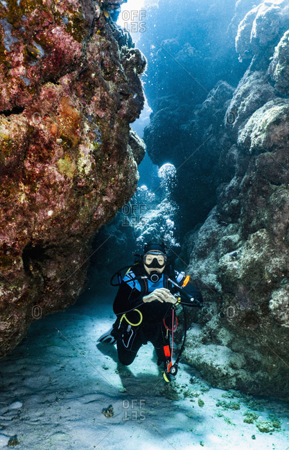 Scuba diver exploring a canyon at the great barrier reef in Australia
