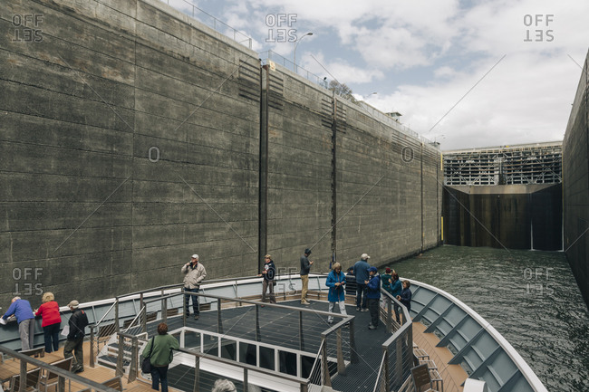 A group of tourists travel through the locks at a dam.