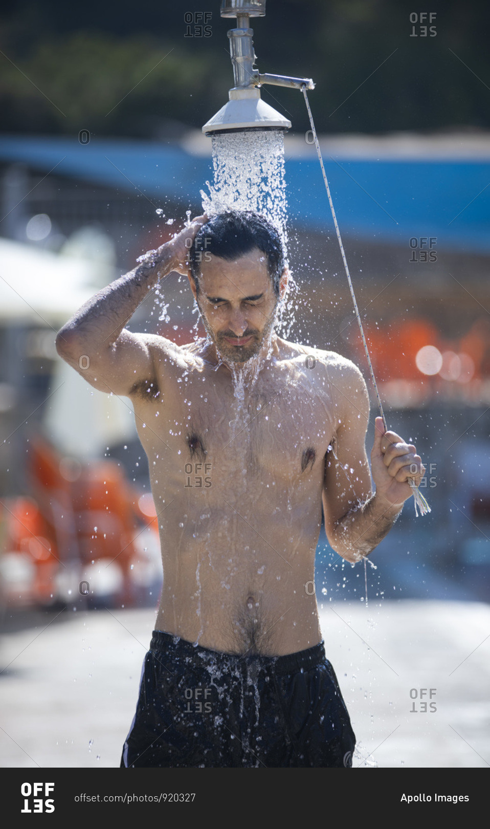 A man or a boy is taking a cold water shower before entering the