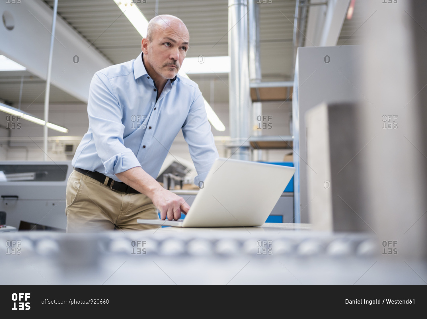 Businessman using laptop in a factory