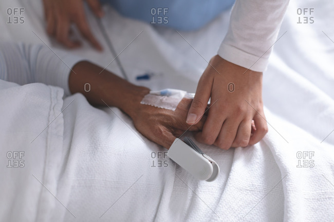 Mid section of female doctor consoling female patient in the ward at hospital