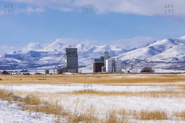 Farm in snowy field by mountains