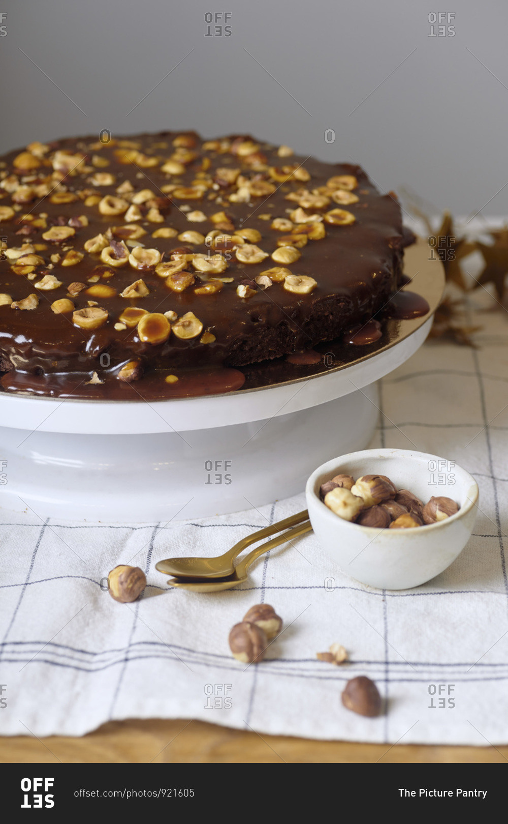 Vegan brownie cake with hazelnuts and salted caramel n white cake stand