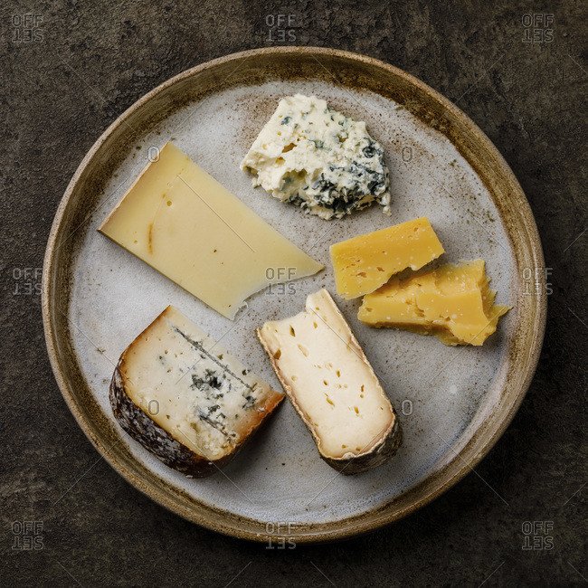 Cheese Plate with different types of cheese Snack assortment on dark background