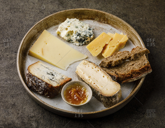 Cheese Plate with different types of cheese Snack assortment on dark background