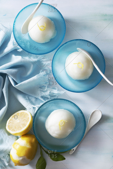 Scoops of lemon sorbet in blue bowls.