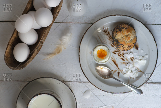 Overview of a cooked egg as breakfast on a white wooden background