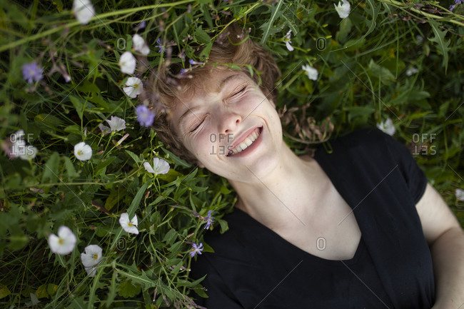 Smiling young woman lying in grass