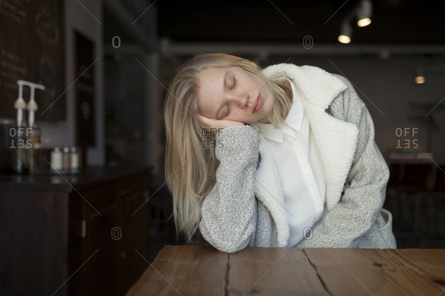 Young woman sleeping at cafe table