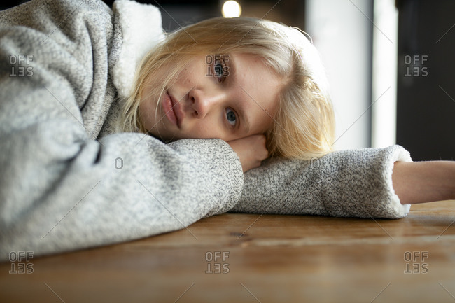 Young woman in wool coat lying on cafe table