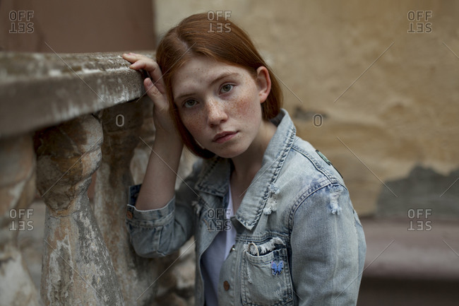 Teenage girl leaning on stone banister