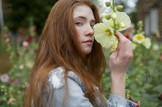 Teenage girl holding flower to her face