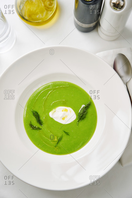 Vibrant green spinach and broccoli soup on whit table