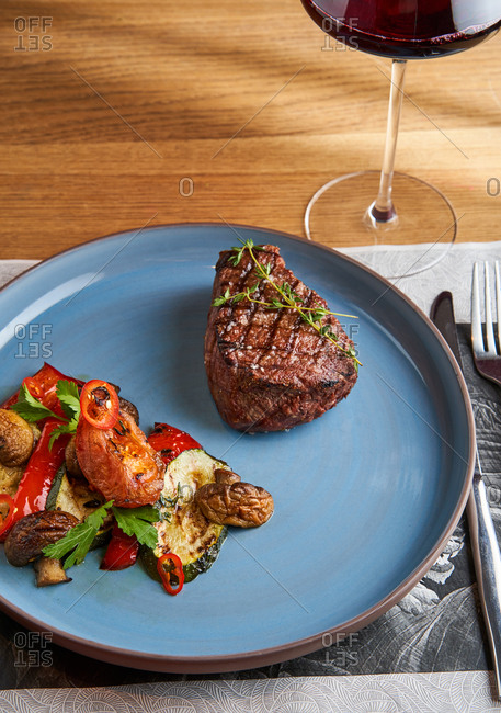Beef fillet mignon with grilled bell pepper, zucchini and champignons in a restaurant setting