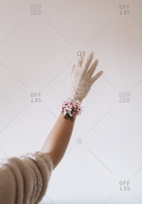 Latex glove covered hand with cherry blossom bracelet
