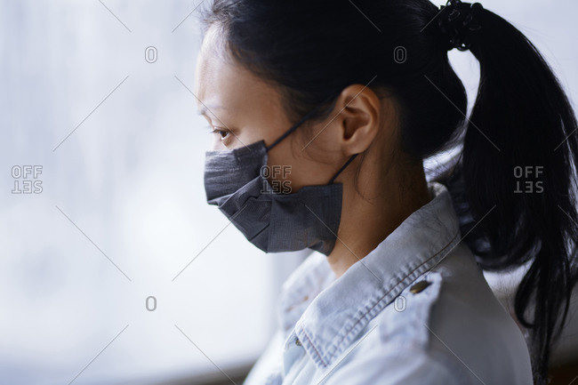 Woman staying at home and wearing protective surgical mask
