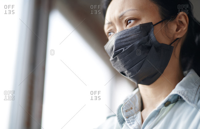 Woman staying at home and wearing protective surgical mask
