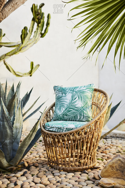 Wicker chair with cushions outdoor in stone garden