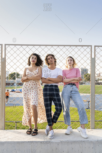 Portrait of cool friends at a wire mesh fence