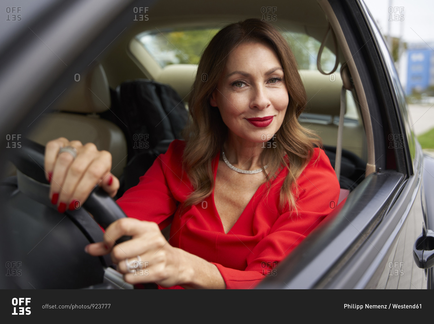 Portrait of smiling mature woman in car stock photo - OFFSET