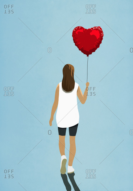 Woman carrying heart shape helium balloon